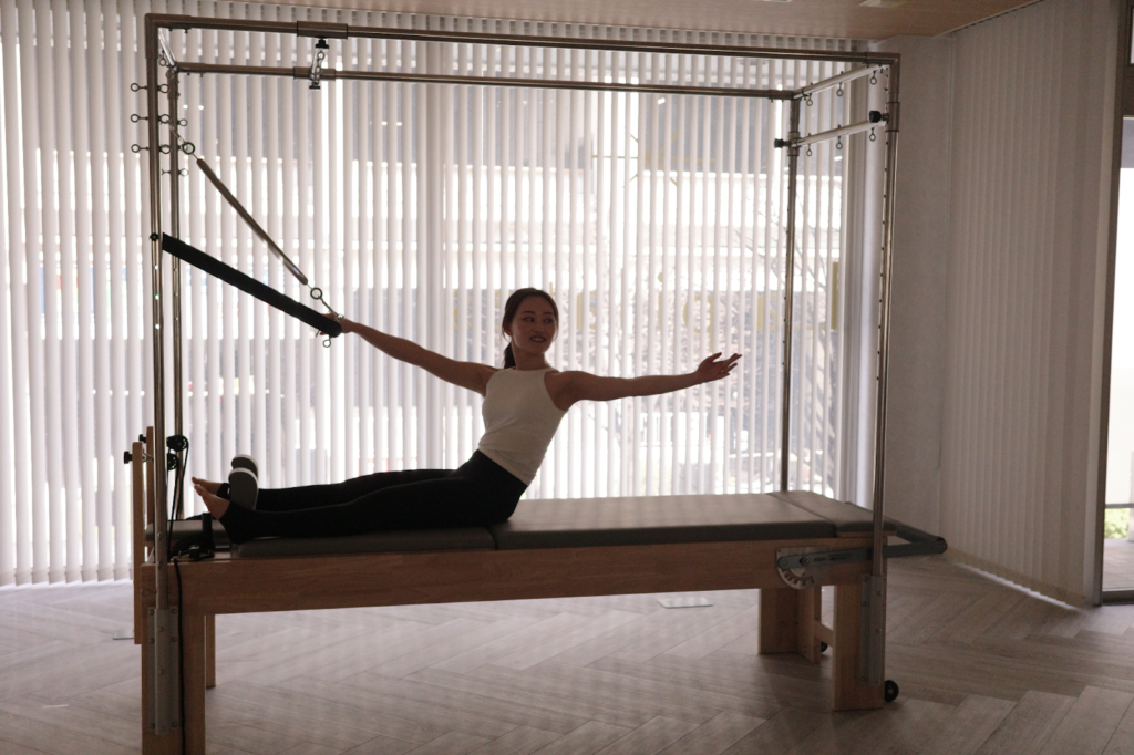 キャデラックマシンを使ってピラティスをする女性