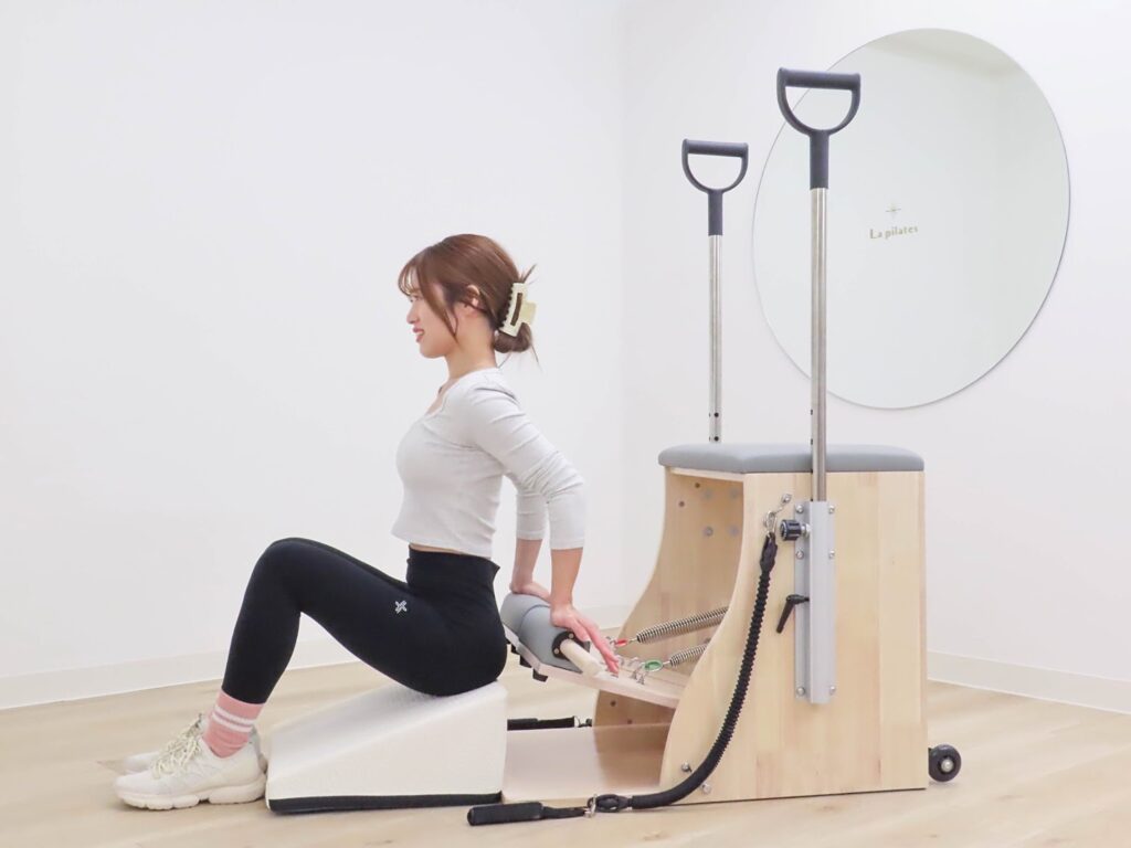 パーソナルマシンピラティススタジオで上半身を整える女性