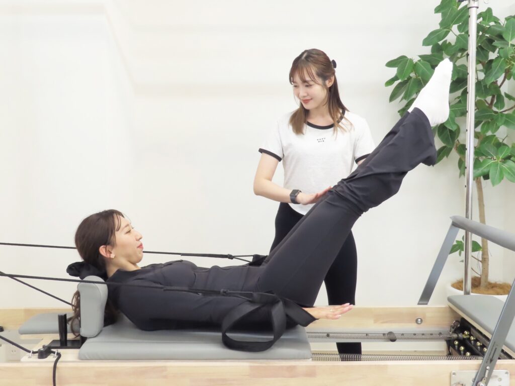 La pilatesのマシンピラティスマンツーマンレッスンでインナーマッスルを鍛える女性